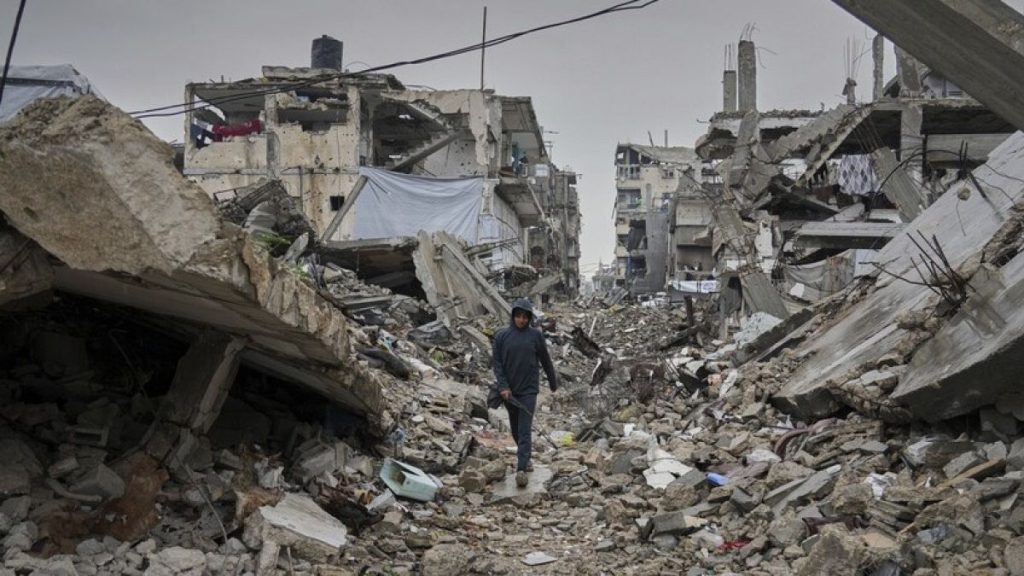 A boy walks down a street covered by the rubble of destroyed homes and buildings in Jabaliya, northern Gaza Strip, Friday March 7, 2025