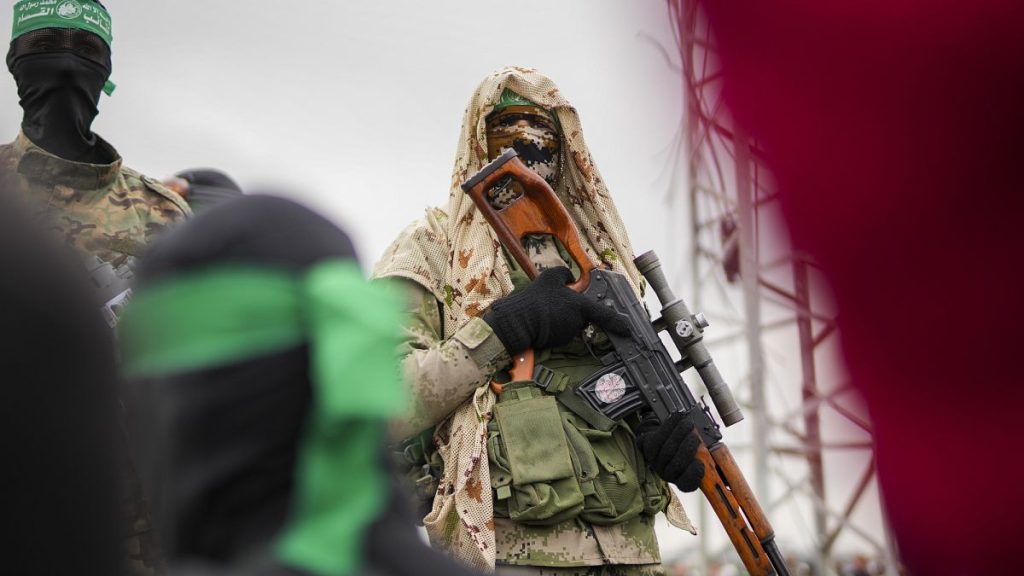A Hamas fighter in combat fatigues stands at the ceremony for the handover of Israeli hostages to the Red Cross in Nuseirat, 22 February, 2025