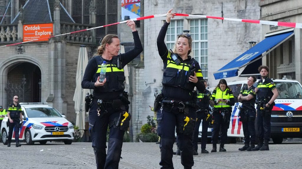 Police officers gather not far from the area after a stabbing near Dam Square in central Amsterdam, 27 March, 2025