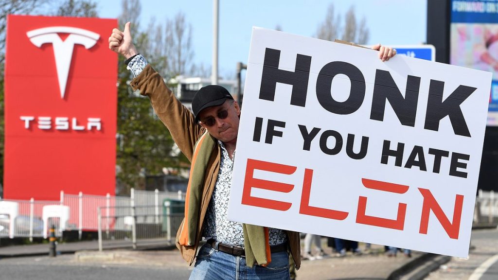 A protester holds a placard as he takes part in the Tesla Takedown Global Day of Action near a Tesla dealership in London, 29 March, 2025