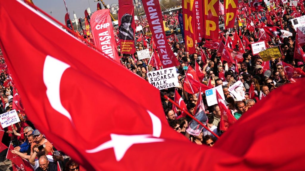People listen to speeches during a rally called by the CHP against the arrest of Istanbul