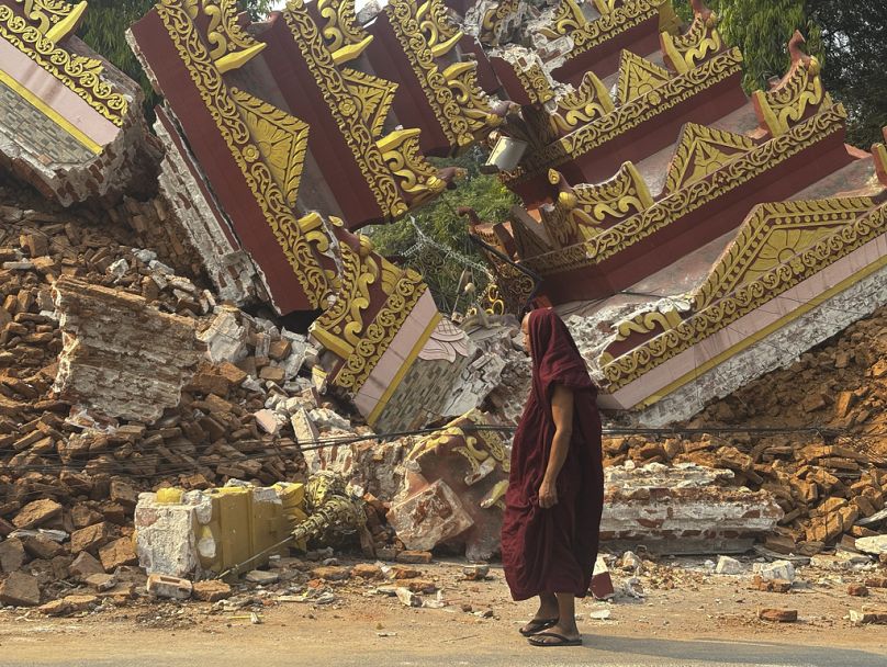 Un moine bouddhiste marche près d'une pagode effondrée après un tremblement de terre à Mandalay, dans le centre du Myanmar, dimanche 30 mars 2025.