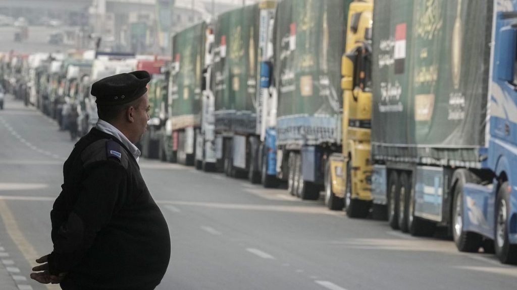 FILE: An Egyptian policeman stands in front of trucks of humanitarian aid for Gaza at a parking point in Cairo, 26 January 2025
