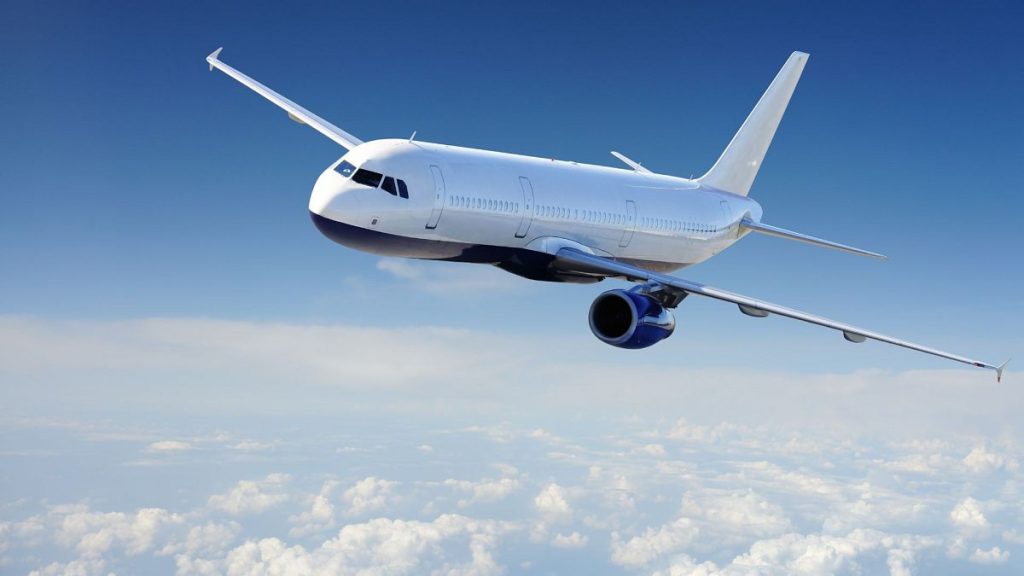 An aeroplane flying against a blue sky.