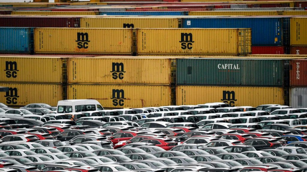 Cars for export and import are stored in front of containers on Thursday, May 16, 2019 at the harbor in Bremerhaven, Germany