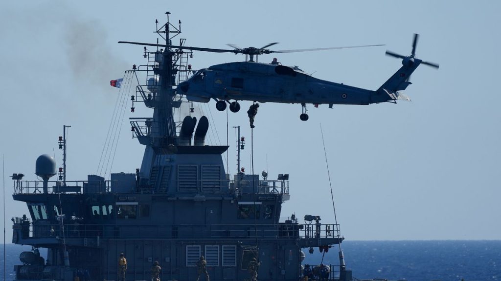 A military helicopter loads marines over a naval ship during an annual NATO naval exercise on Turkey