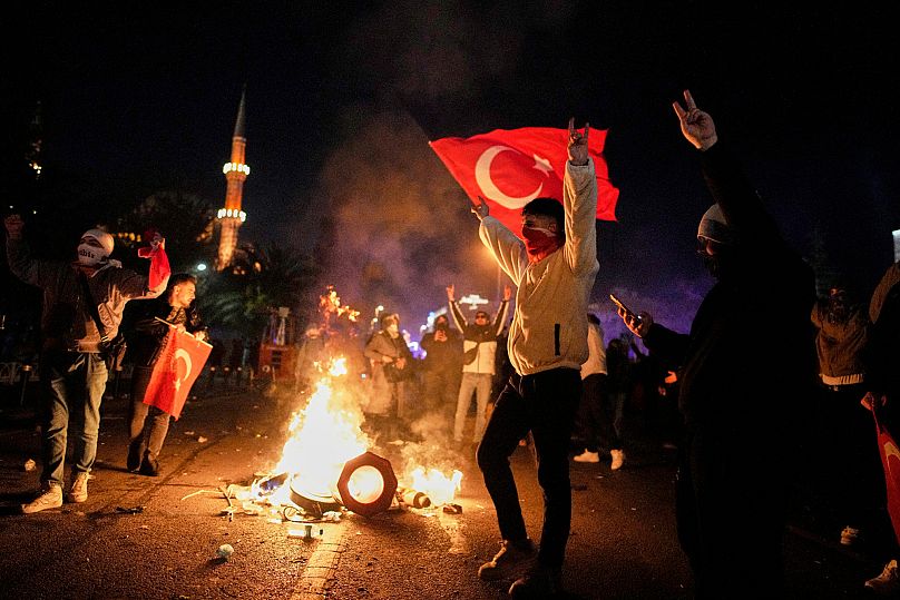 Les manifestants crient des slogans lors des affrontements avec la police anti-émeute lors d'une manifestation contre l'arrestation du maire d'Istanbul, Ekrem İmamoğlu, à Istanbul, 21 mars 2025