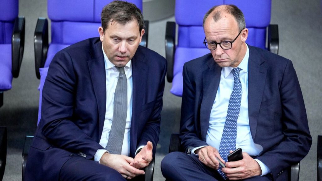 Friedrich Merz, leader of the Christian Democratic Union, right, and Social Democratic Party leader Lars Klingbeil talk during a meeting of the Bundestag, March 13, 2025.