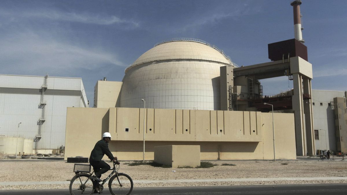 FILE - A worker rides a bicycle in front of the reactor building of the Bushehr nuclear power plant, just outside the southern city of Bushehr, Iran, Oct. 26, 2010