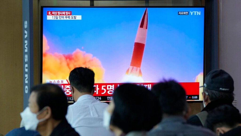FILE- People watch a TV showing a file image of North Korea