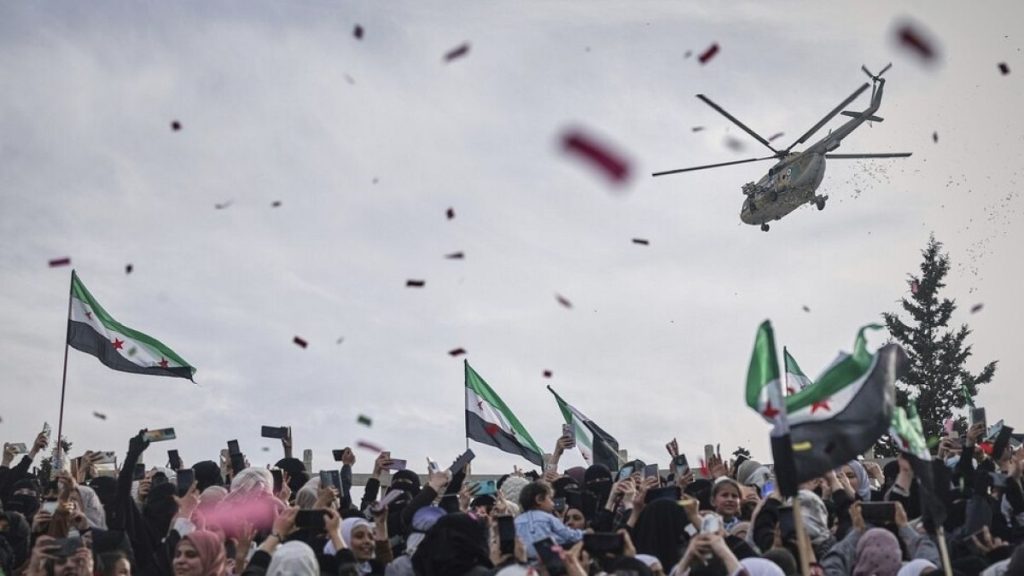 Confetti and flowers are dropped from a military helicopter onto a crowd during a celebration of victory of rebel forces over al-Assad