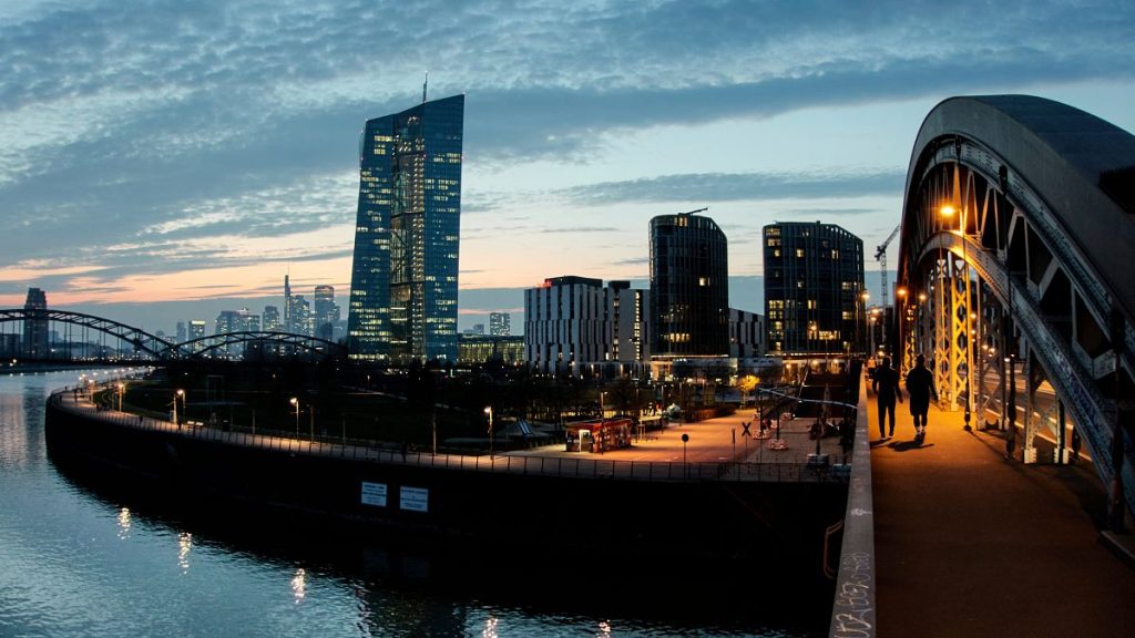 People walk on a bridge over the river Main near the European Central Bank in Frankfurt, Germany. 25 March 2025.