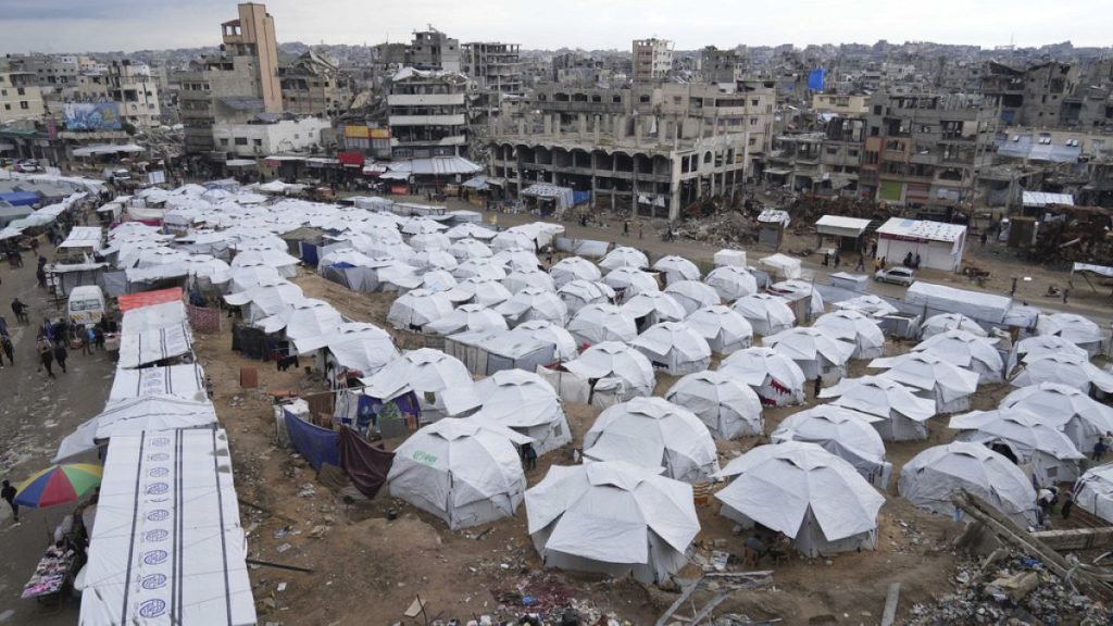 A sprawling tent camp for displaced Palestinians sits adjacent to destroyed homes and buildings in Gaza City, Gaza Strip, Saturday, March 1, 2025