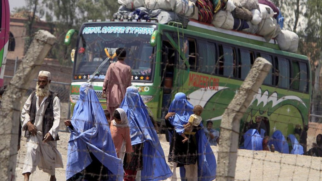 An Afghan family walk to their bus to leave for Afghanistan at a UNHCR repatriation terminal in Peshawar, Pakistan, 24 May 2009.