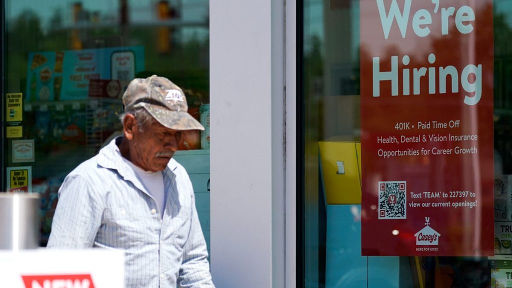 A hiring sign is displayed at a gas station as a customer walks past in Buffalo Grove, Ill., Thursday, June 9, 2022.