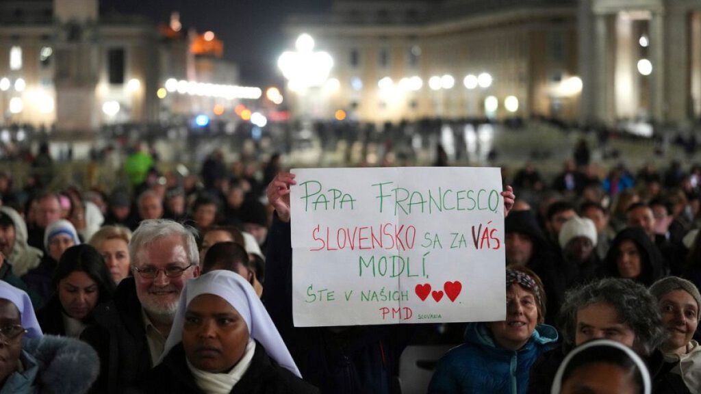 People hold up a banner before Cardinal Robert Francis Prevost in St Peter