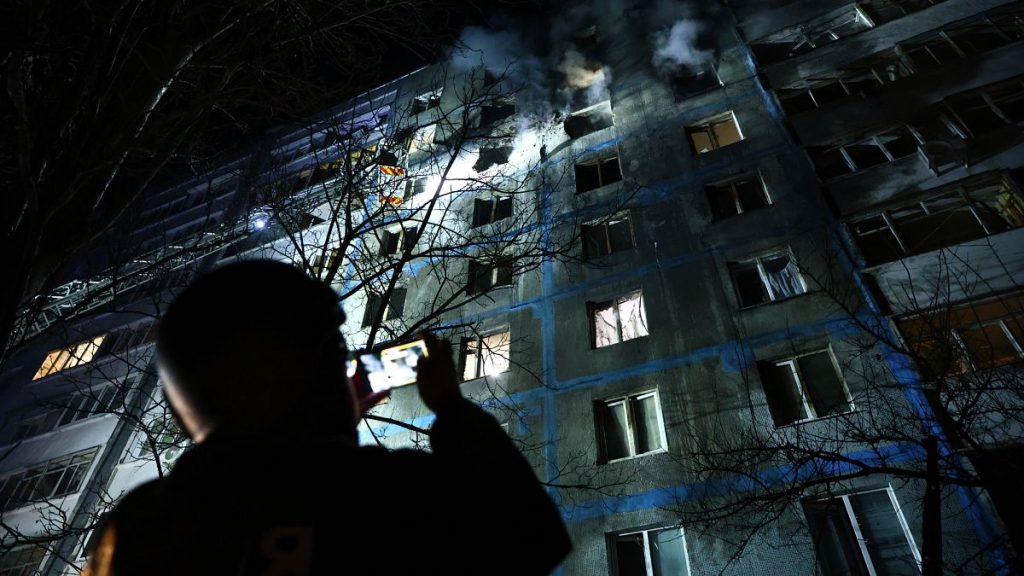 A rescue worker takes photo of a multi-storey building damaged by a Russian drone strike on a residential neighbourhood in Zaporizhzhia, 28 February, 2025
