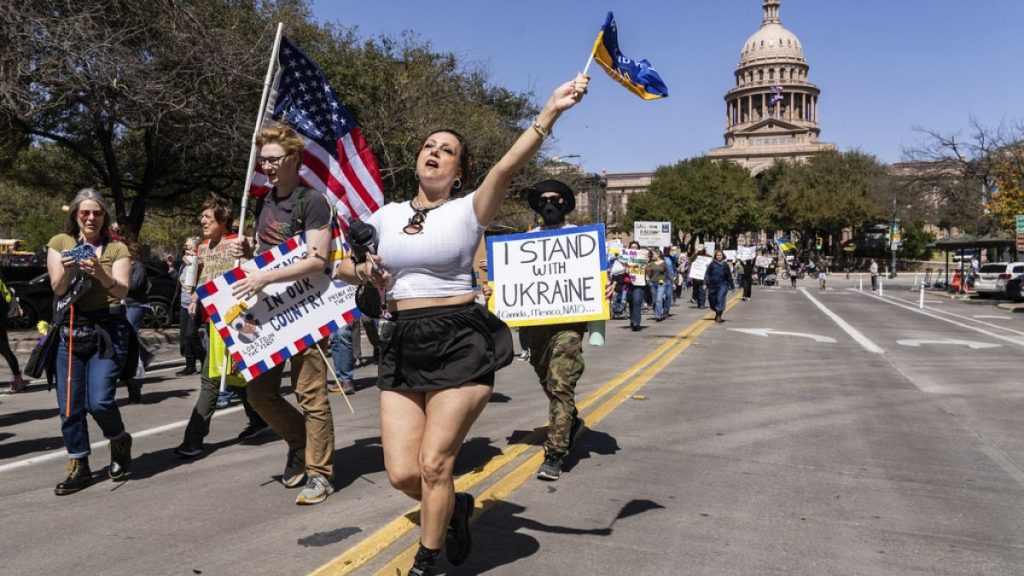 Nicole Surginer waves a Ukrainian flag during a protest against the Trump administration
