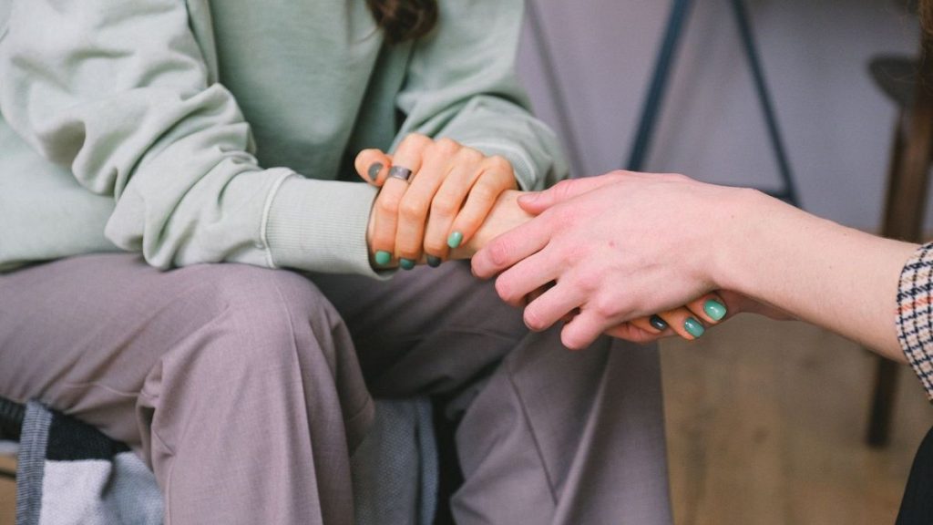 Two people hold hands.