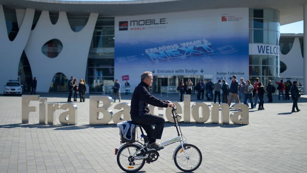 A man rides his bicycle outside the Mobile World Congress, the world