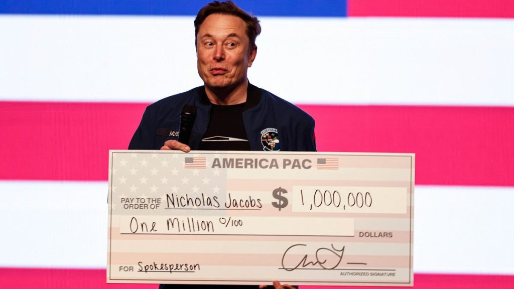 Elon Musk holds a check for $1 million at a town hall on 30 March, 2025, in Green Bay, Wisconsin.