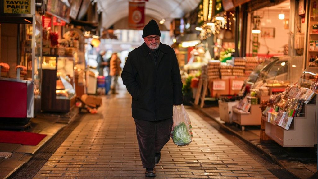 A man carries a bag with groceries in a food street market at Uskudar neighbourhood in Istanbul, Turkey, Thursday, Jan. 23, 2025.