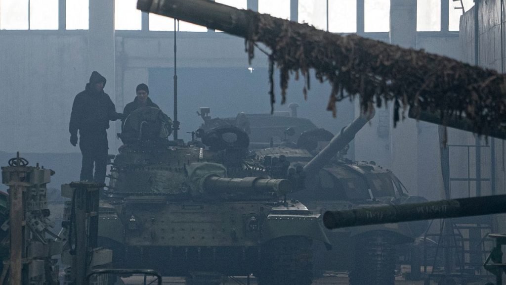 Workers stand atop a tank T-64 on Repair Tank Factory in Kharkiv, Ukraine.
