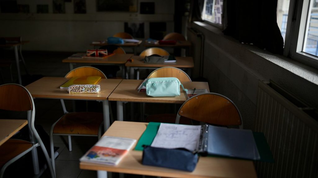 An empty classroom as schoolchildren and educators observe a moment of silence outside at the College Gaston Defferre in Marseille, southern France, 16 October 2023.