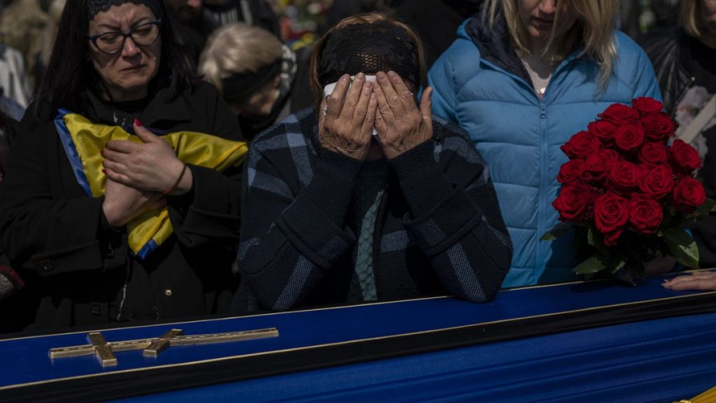 Relatives mourn next to the coffin of Ukrainian serviceman Andrii Vorobiov at the Kryvyi Rih cemetery in eastern Ukraine, Monday, April 24, 2023