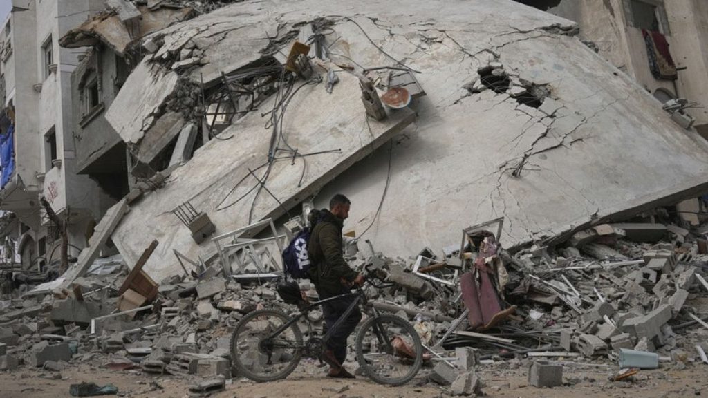 A man passes by a destroyed house in an Israeli army strike in Khan Younis, southern Gaza Strip, Sunday, April 6, 2025