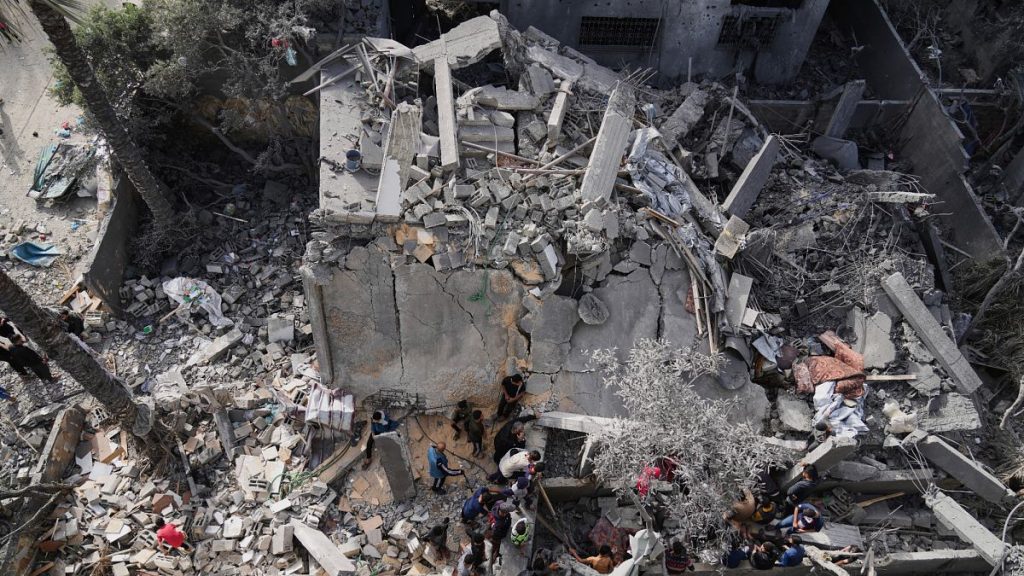 Palestinians search for survivors amid the debris of a building destroyed by an Israeli airstrike in Deir al-Balah, 7 April, 2025