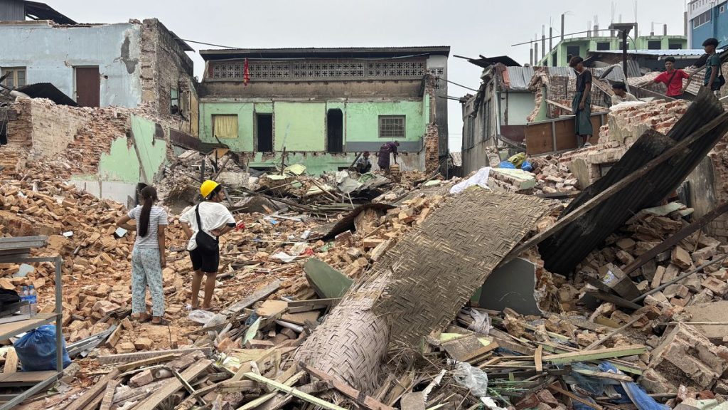 People clean debris from damaged buildings in the aftermath of an earthquake in Naypyidaw, 7 April, 2025