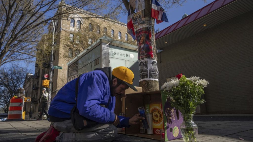 A person lights candles at a makeshift vigil for the victims of the Jet Set club roof collapse in the Dominican Republic, Wednesday, April 9, 2025, in New York. (AP Photo/Adam