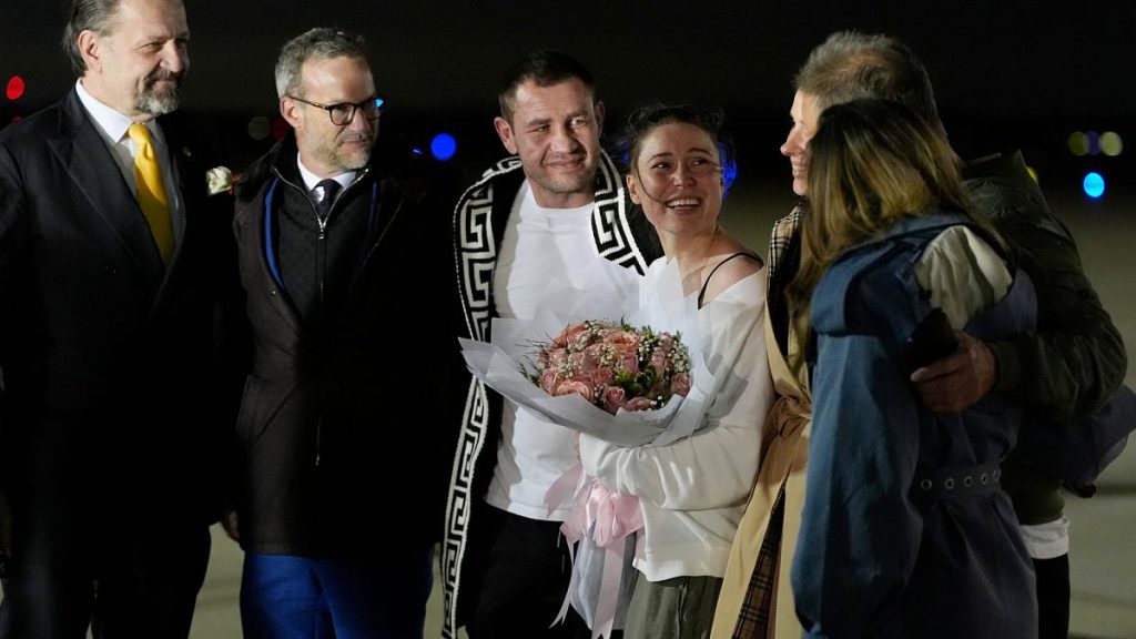 Ksenia Karelina and her fiancé, professional boxer Chris van Heerden, talks on the tarmac as she arrives Thursday, April 10, 2025, at Joint Base Andrews, Md. (AP Photo/Alex Br