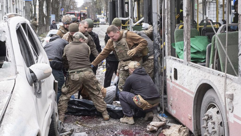 Ukrainian servicemen carry a dead body from a trolleybus after a Russian missile strike on Sumy, Ukraine, Sunday, April 13, 2025