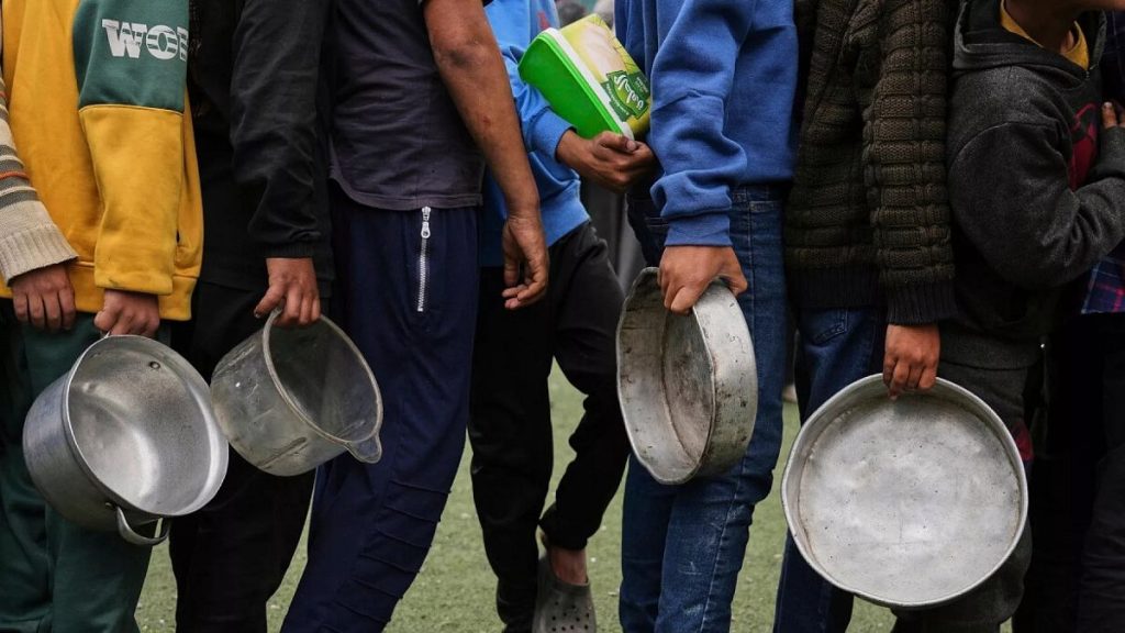Palestinian children line up to wait for donated food at a distribution centre in Nuseirat, central Gaza Strip,11 April 2025