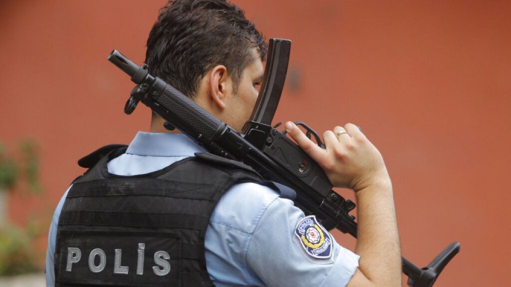 An armed Turkish police officer secures a road leading to the U.S. Consulate building in Istanbul, Monday, Aug. 10, 2015.