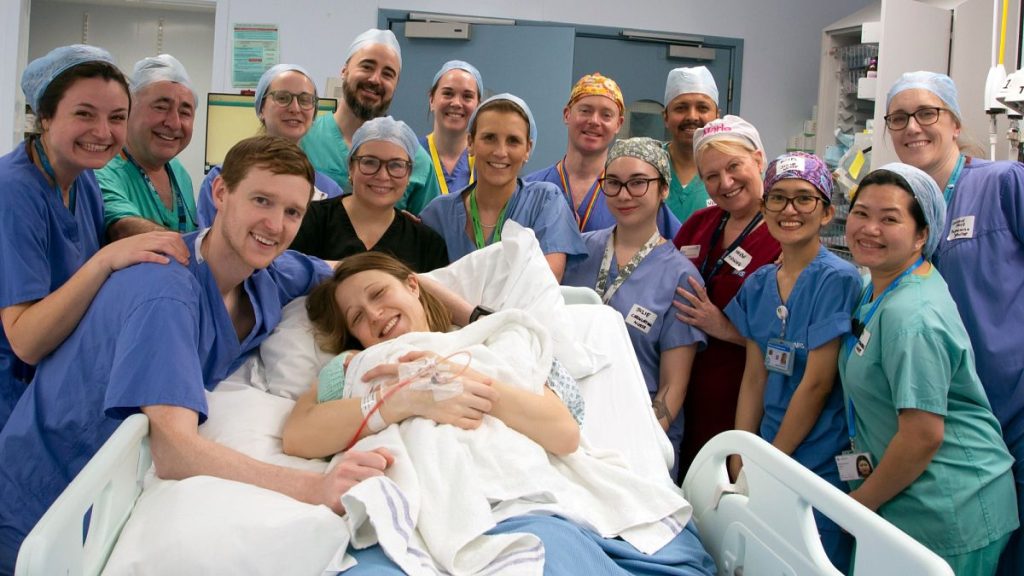 The Davidson parents smile with their newborn baby and medical team.