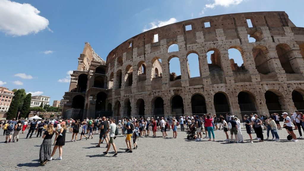 Tourists wait in a queue to enter the Colosseum in Rome, Italy.