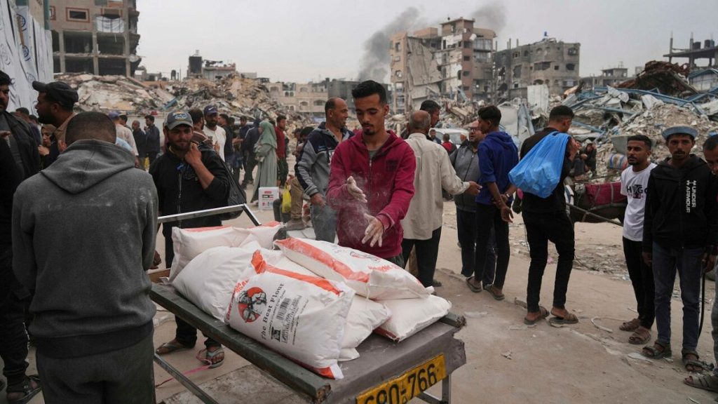 Palestinians receive bags of flour and other humanitarian aid distributed by UNRWA, the U.N. agency helping Palestinian refugees in Jabaliya, Gaza Strip, April 1, 2025.