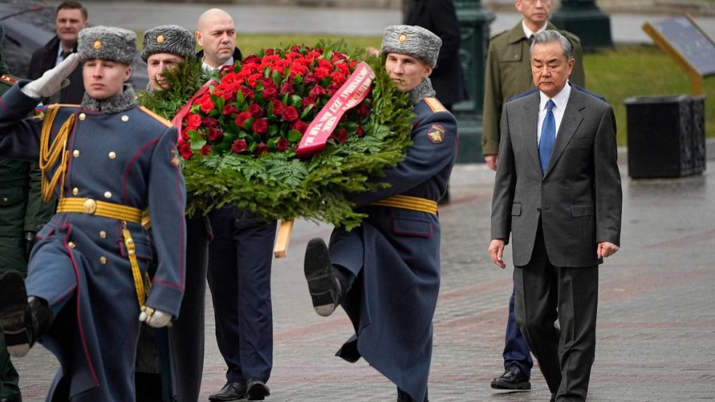 Chinese Foreign Minister Wang Yi, right, attends a wreath-laying ceremony at the Tomb of the Unknown Soldier near the Kremlin wall in Moscow.