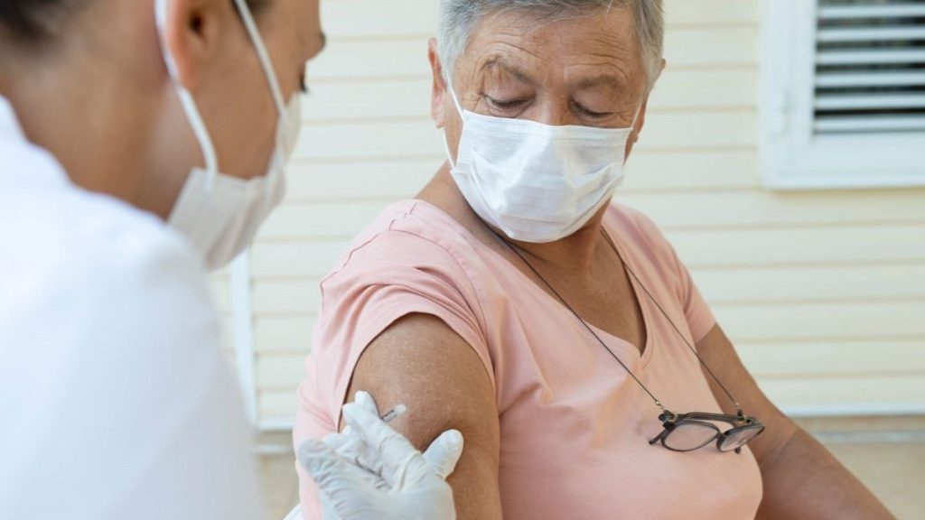 An older woman receives a vaccination.