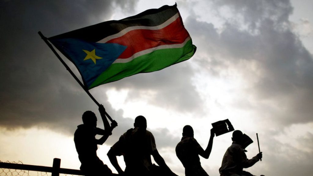 FILE - Southern Sudanese wave the national flag and cheer at South Sudan