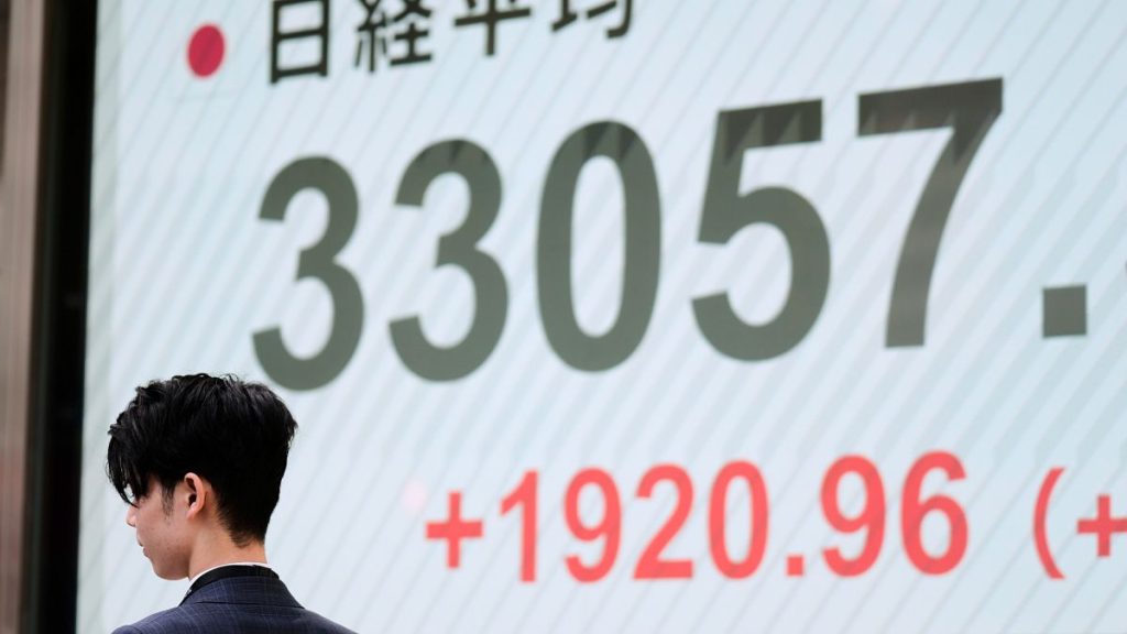 A man walks by monitors showing Japan