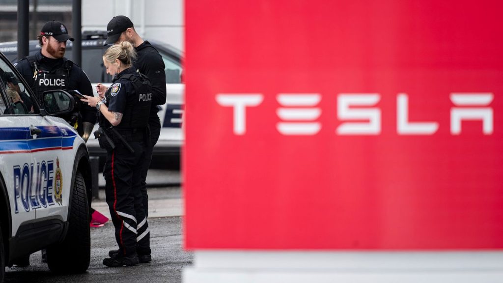 Officers from Ottawa Police Service (OPS) are seen at a Tesla Service and Showroom centre after it was damaged with pink spray paint in Ottawa, on Monday, March 31, 2025.