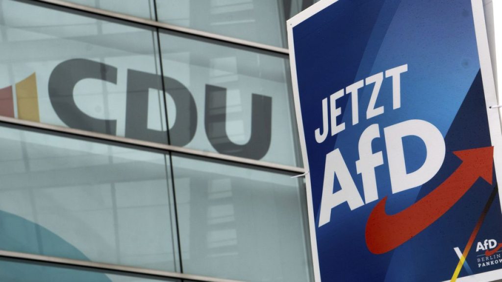 An election poster of the far-right AfD party, right, is displayed on a lamppost in front of the CDU