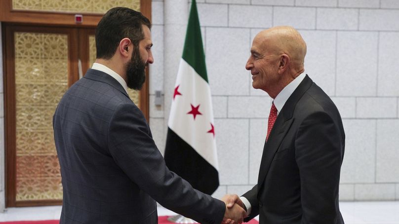 Le président par intérim de la Syrie, Ahmad al-Sharaa, à gauche, serre la main avec l'ambassadeur américain en Turquie et envoyé spécial de Syrie Tom Barrack, à Damas, Syrie, 29 mai 2025