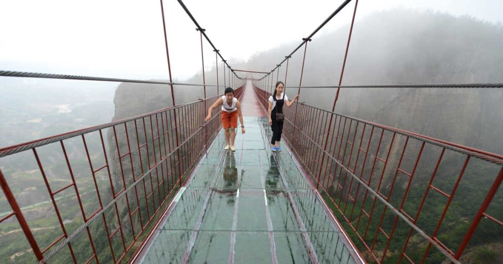 En Chine un pont de verre cède et piège un touriste à 100 m de haut