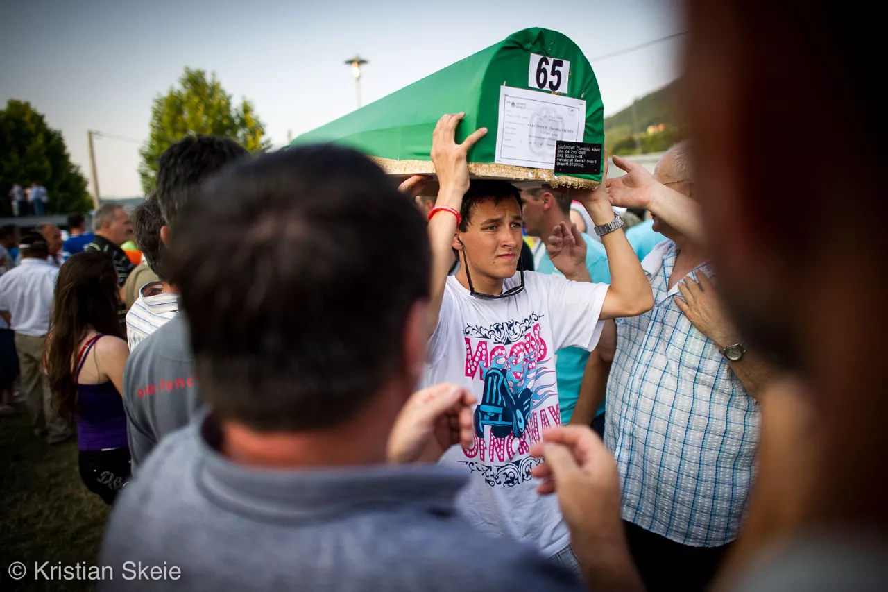 Un jeune homme portant le cercueil d'un être cher.