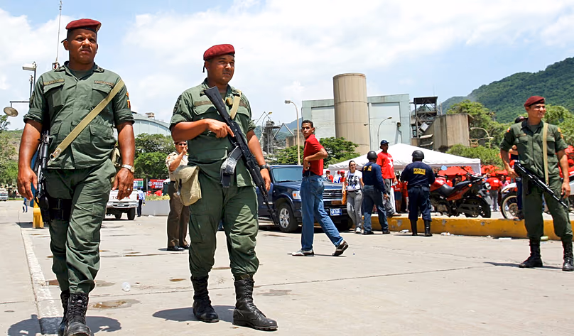 DOSSIER – Dans cette photo d'archive du 19 août 2008, des soldats de la Garde nationale patrouillent devant l'usine CEMEX à Pertigalete, au Venezuela.